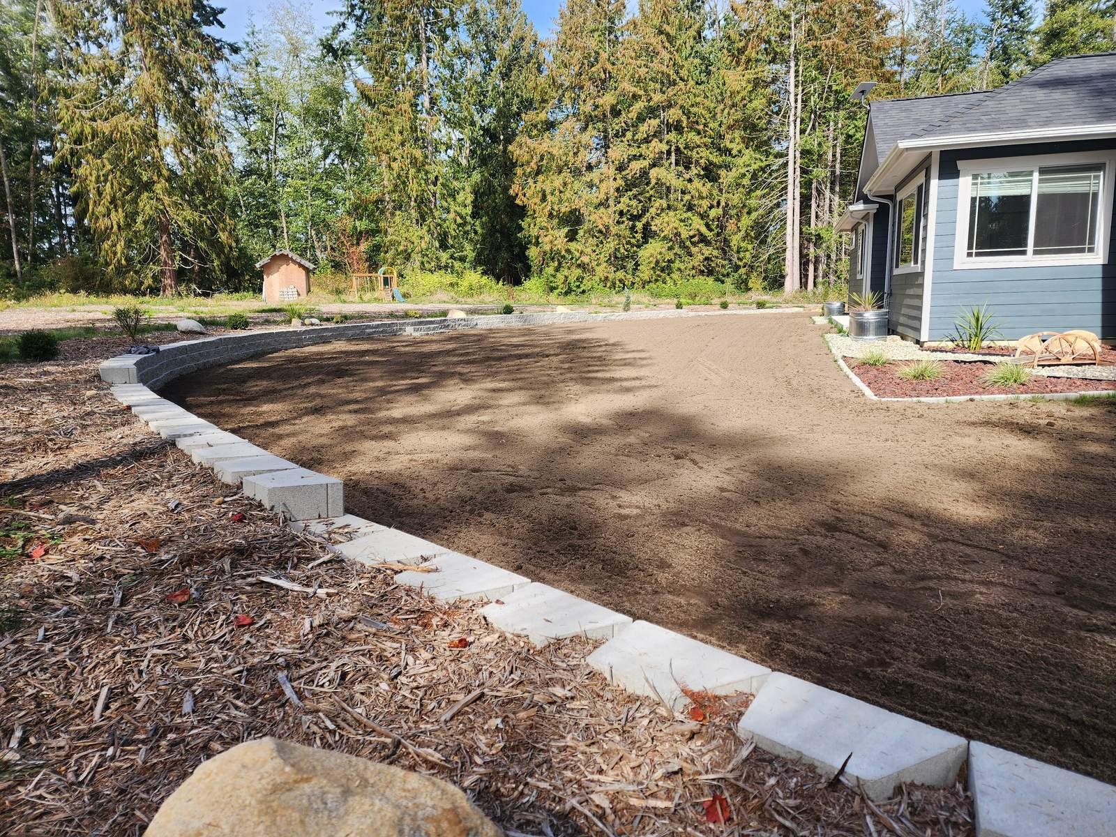 Leveled and graded yard area with concrete curbing and mulch border