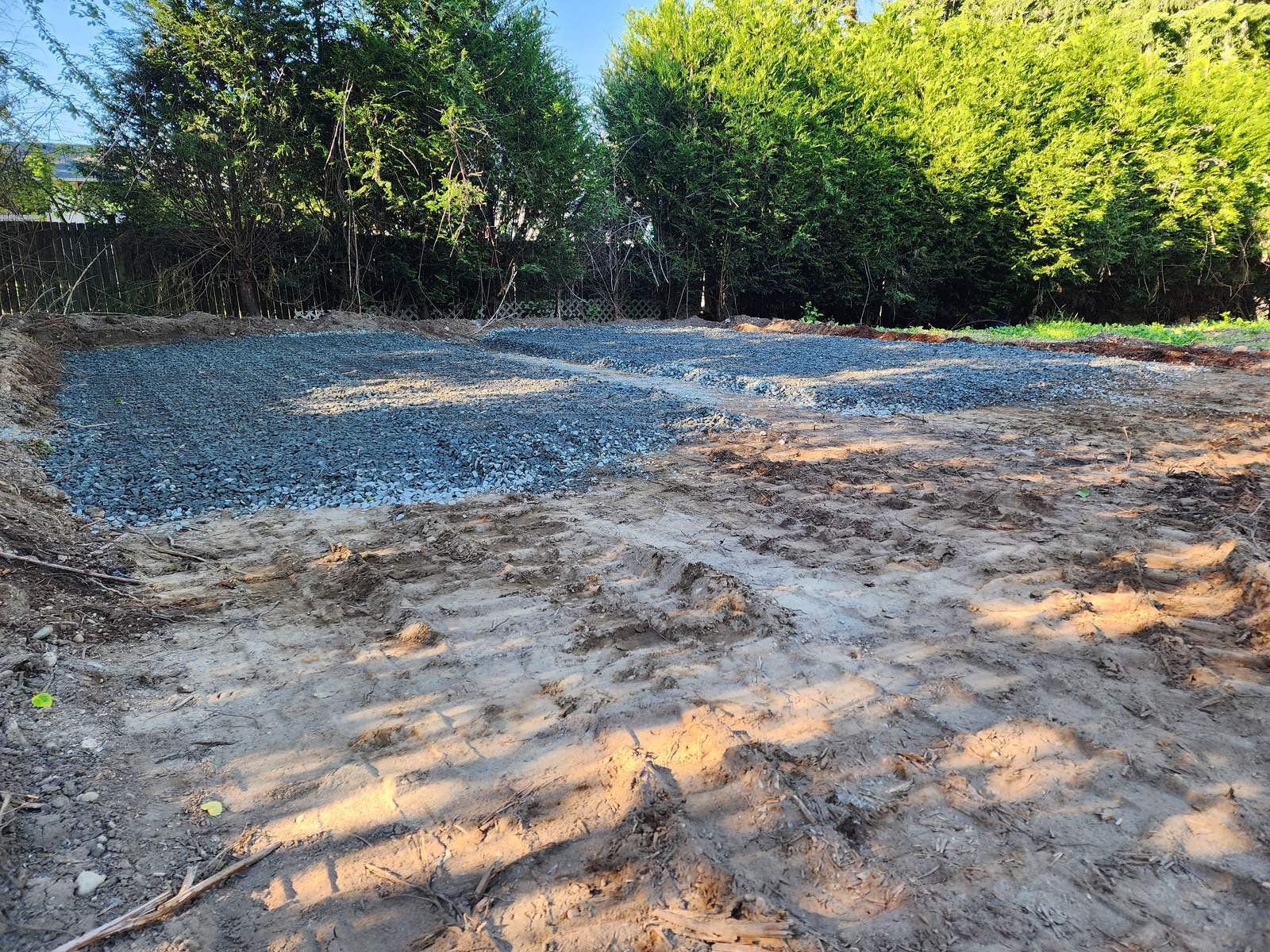 Graded lot with crushed gravel being spread for a building pad